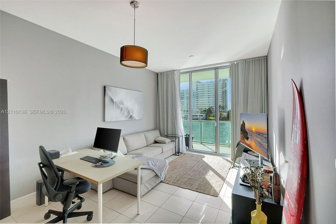Floor-to-ceiling sliding glass doors, tile flooring, and a pendant light fixture
