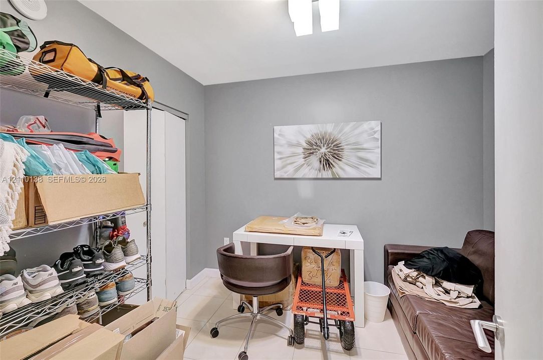 Neutral-toned interior space featuring light-colored tile flooring, overhead recessed lighting, and double-panel closet doors