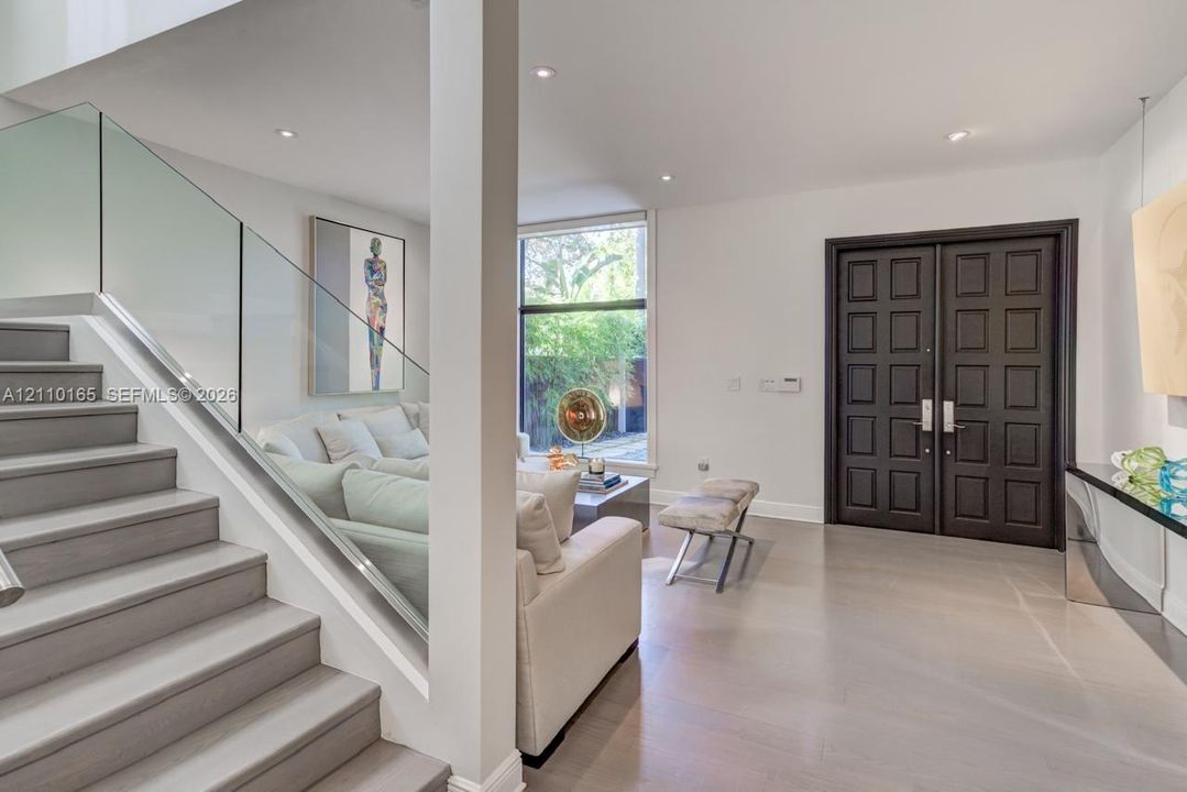 Foyer featuring double entry doors with raised panel detailing, wood-finish flooring, recessed lighting, and a staircase with a glass-paneled railing