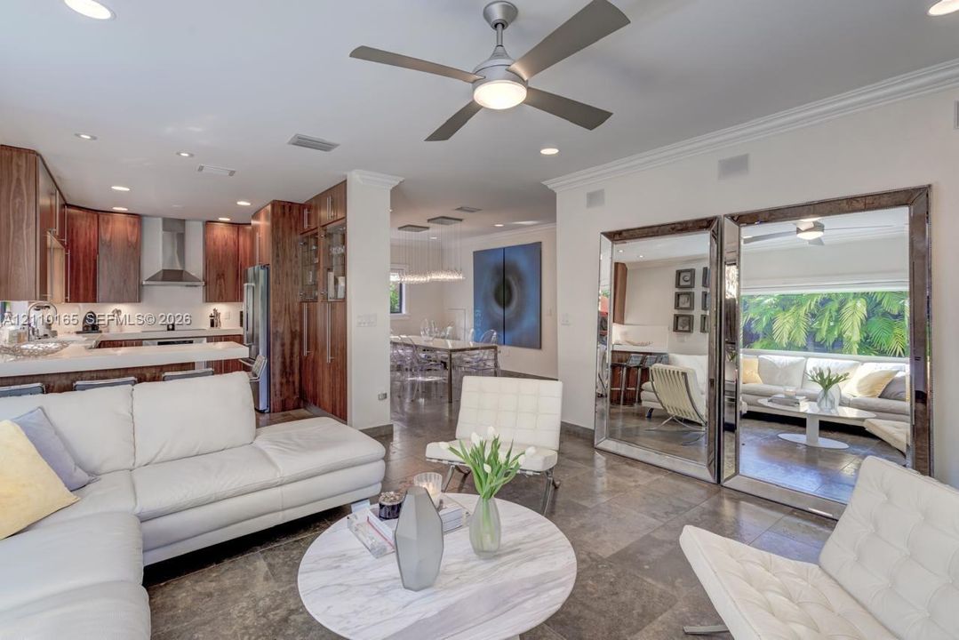 Open-concept interior featuring stone flooring, cabinetry with wood-finish doors, recessed ceiling lighting, and a dual-blade ceiling fan