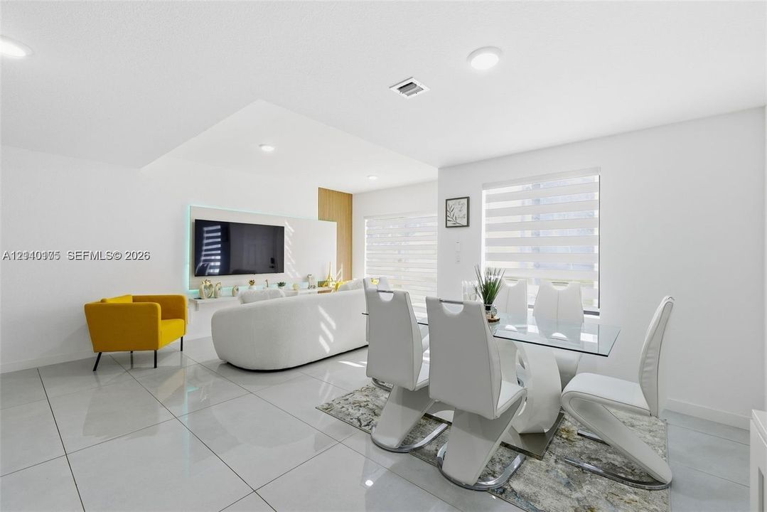 Large-format tile flooring, recessed ceiling lighting, and a custom media wall with integrated accent lighting