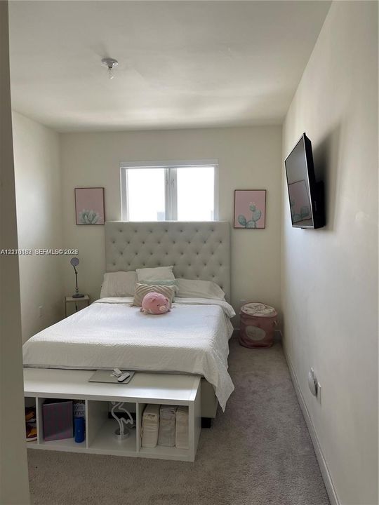 Room featuring wall-to-wall carpeting, neutral-toned walls, and a window with a white frame