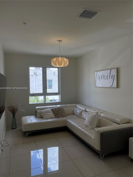Large-format tile flooring, neutral wall tones, multi-pane window, and a modern drum-style pendant light fixture