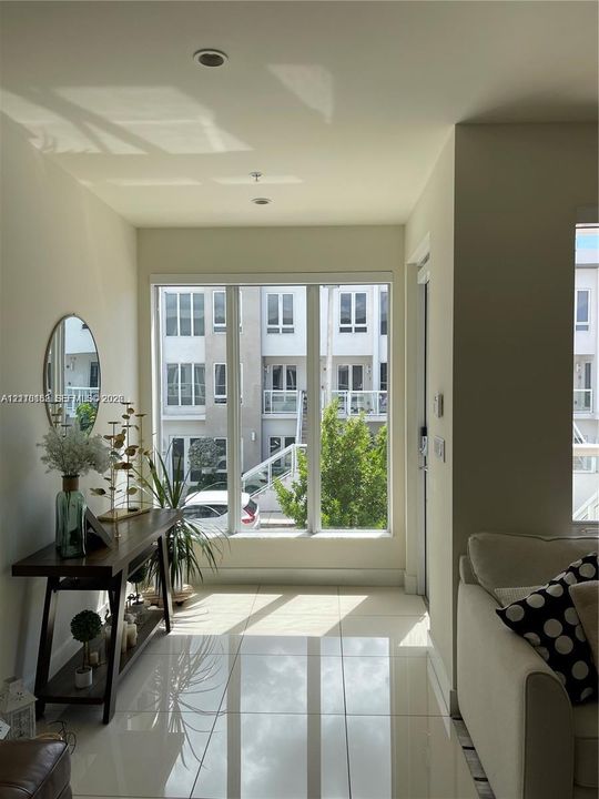 Floor-to-ceiling windows, high-gloss tile flooring, and recessed ceiling lighting