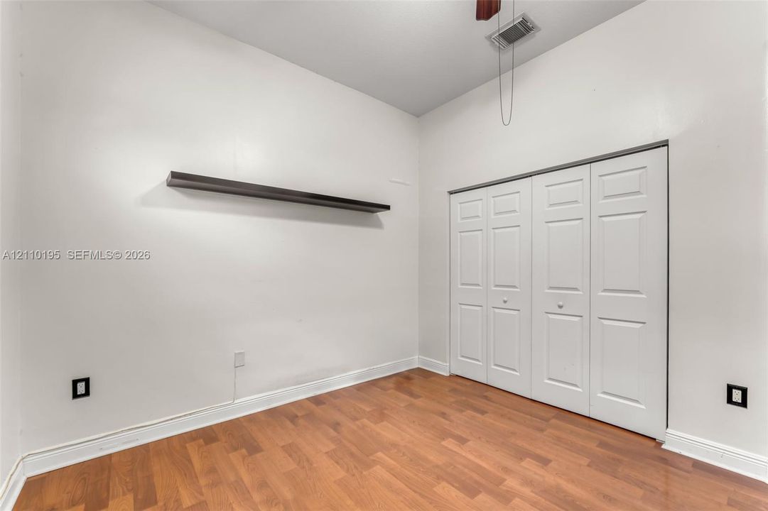 Wood-finish flooring, vaulted ceilings, and a built-in wall shelf