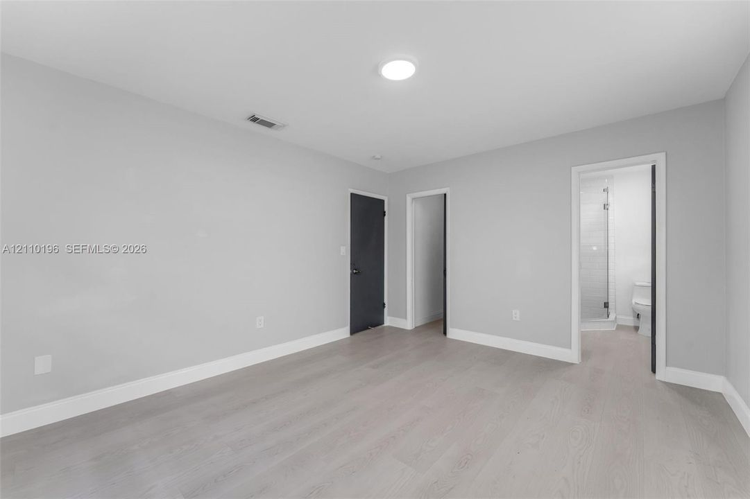 Neutral interior space featuring wood-finish flooring, recessed lighting, and solid-core doors