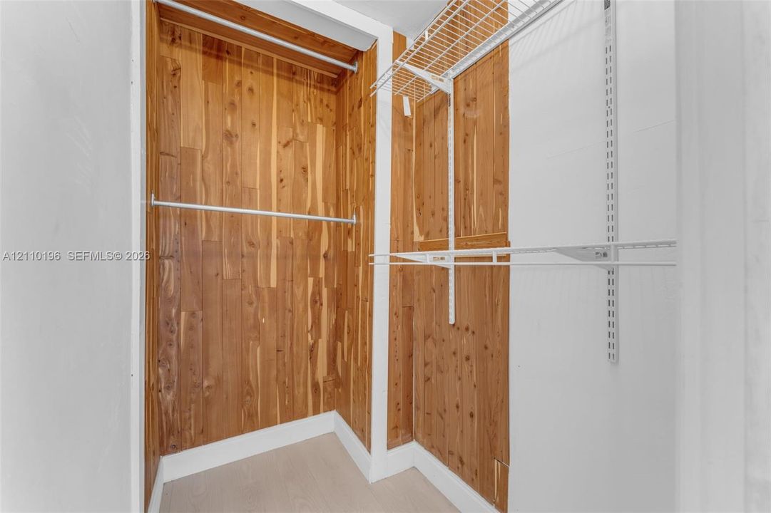 Walk-in closet featuring cedar-lined interior walls, integrated wire shelving, and metal garment rods