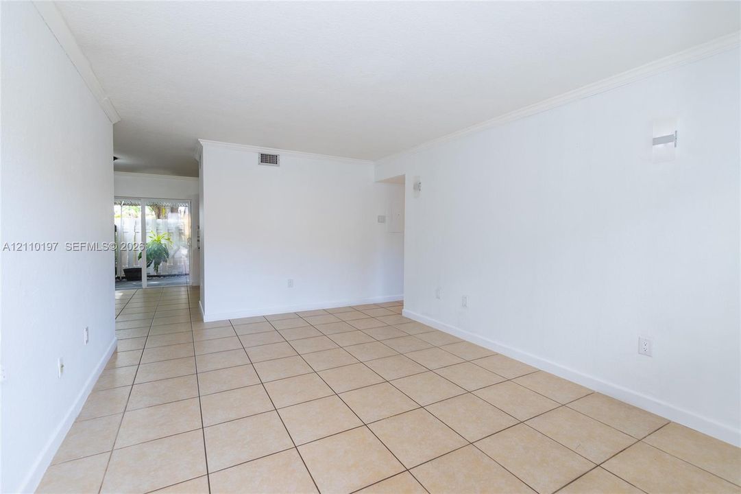 Neutral-toned tile flooring, white wall finishes, and glass sliding doors