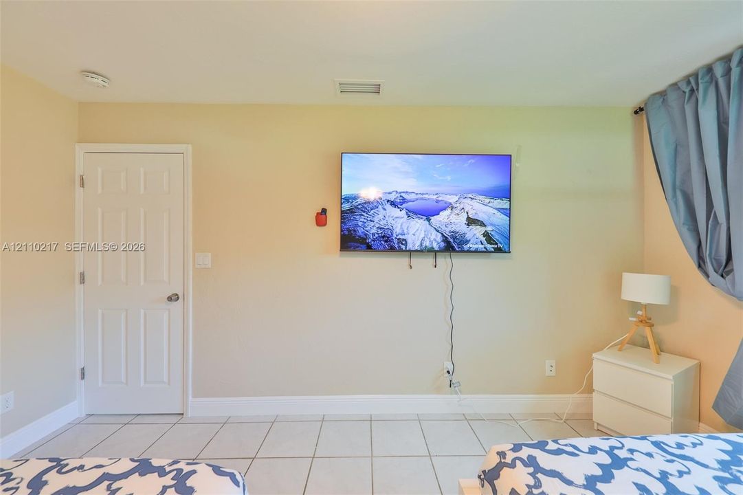 Interior space featuring large-format ceramic tile flooring and a solid-core interior door with brushed nickel hardware