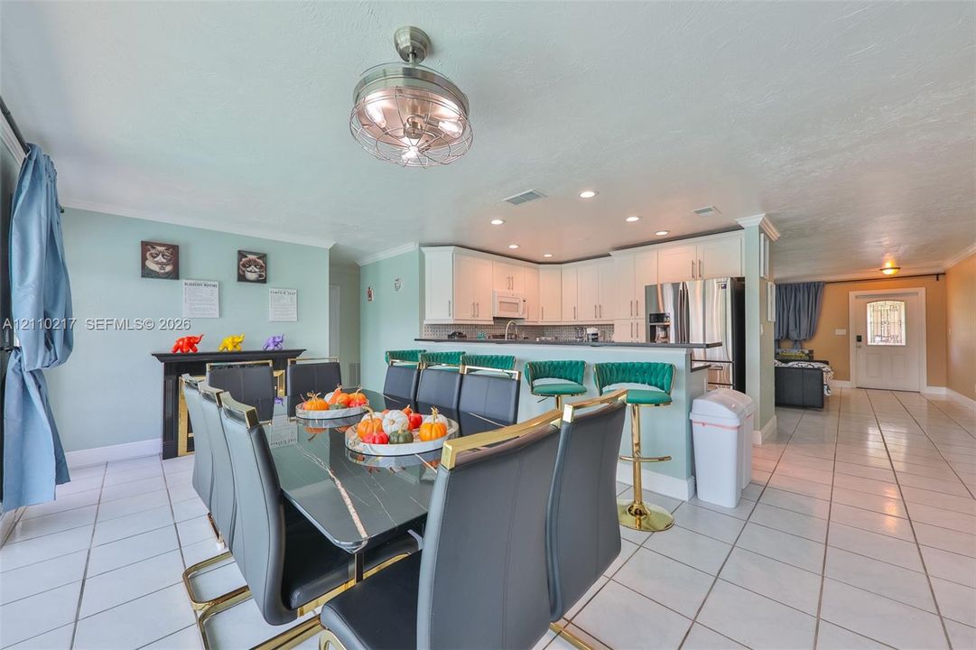 Open-concept kitchen featuring white cabinetry, recessed lighting, and a breakfast bar
