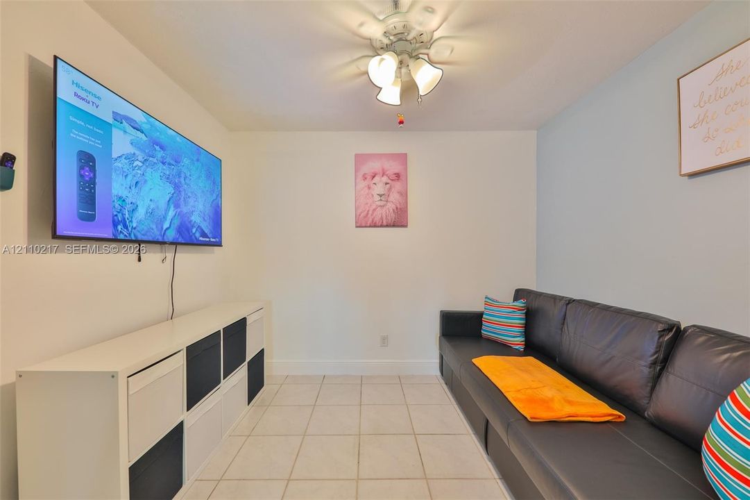 Interior space featuring neutral wall tones, ceramic tile flooring, and a multi-light ceiling fan