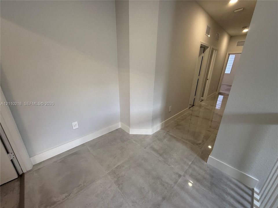Polished large-format tile flooring and recessed ceiling lighting