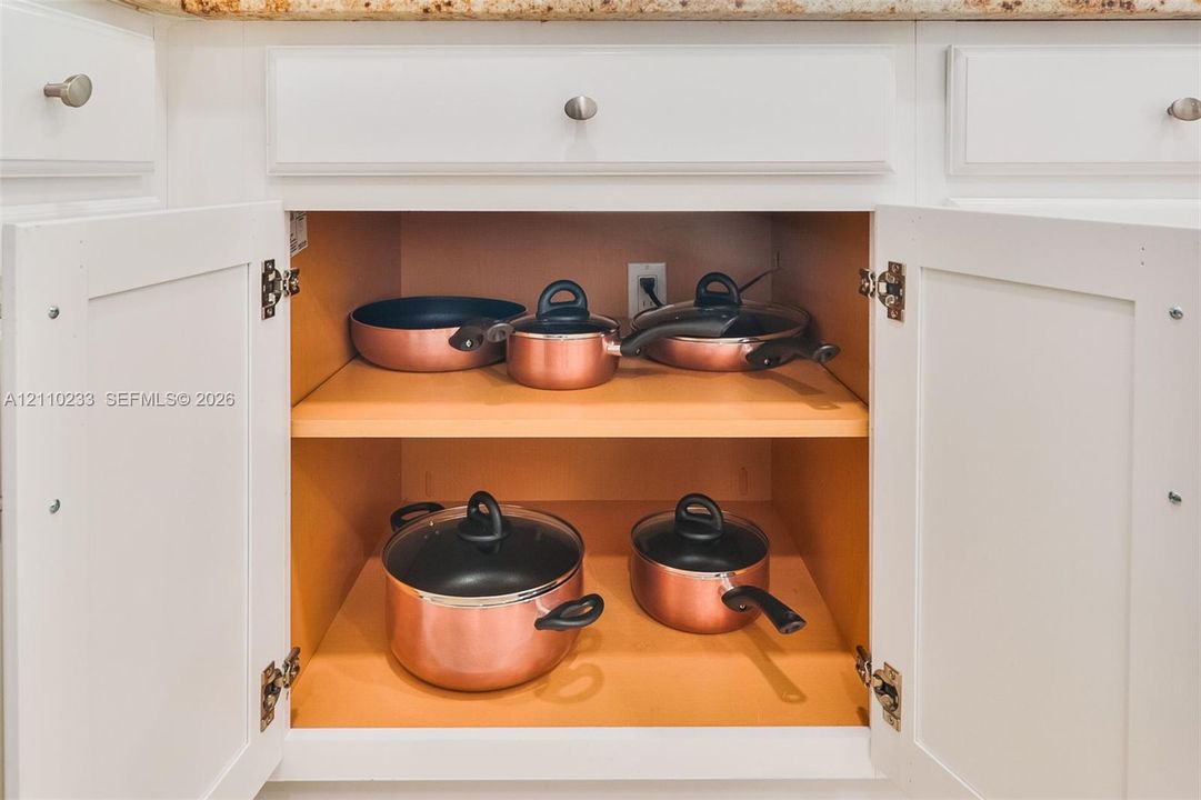 Shaker-style cabinetry featuring white finish, silver-tone hardware, and adjustable shelving