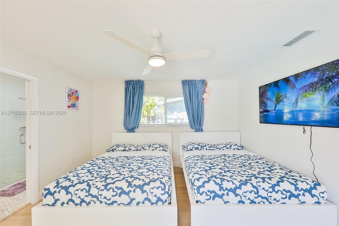 Interior space featuring a white ceiling fan with integrated lighting and wood-finish flooring