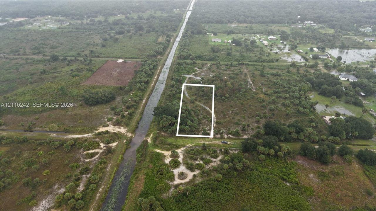Expansive vacant lot featuring native vegetation and mature tree clusters