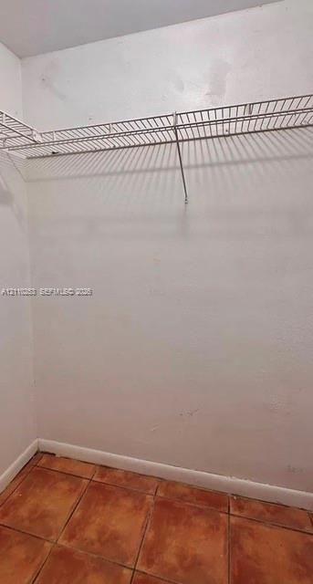 Storage area featuring ceramic tile flooring and white wire shelving