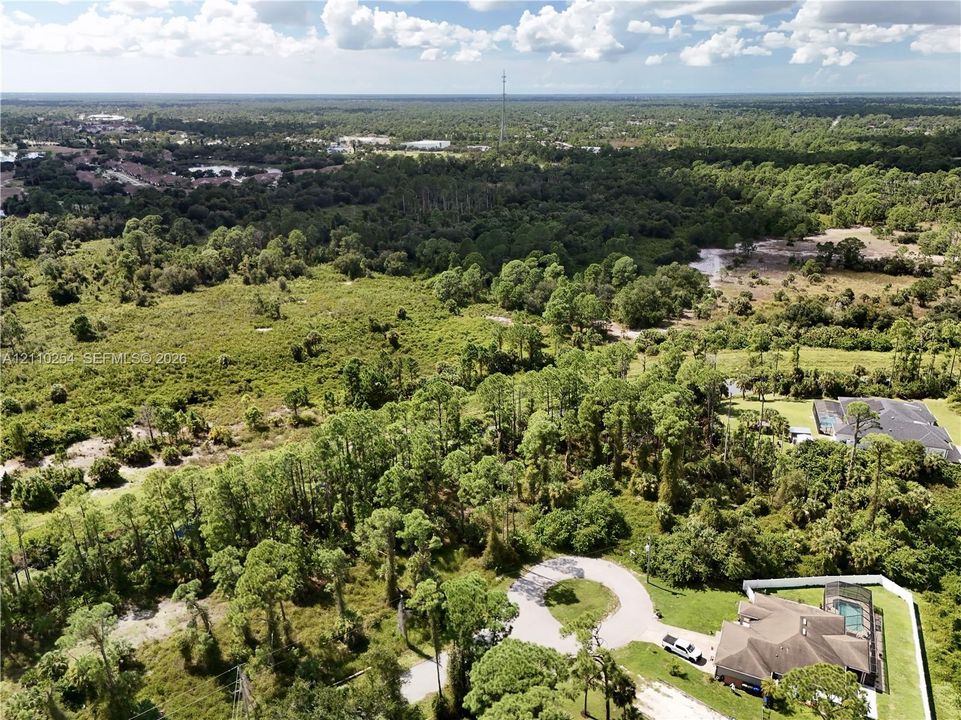 Aerial perspective featuring extensive wooded acreage, native vegetation, and a private cul-de-sac entry