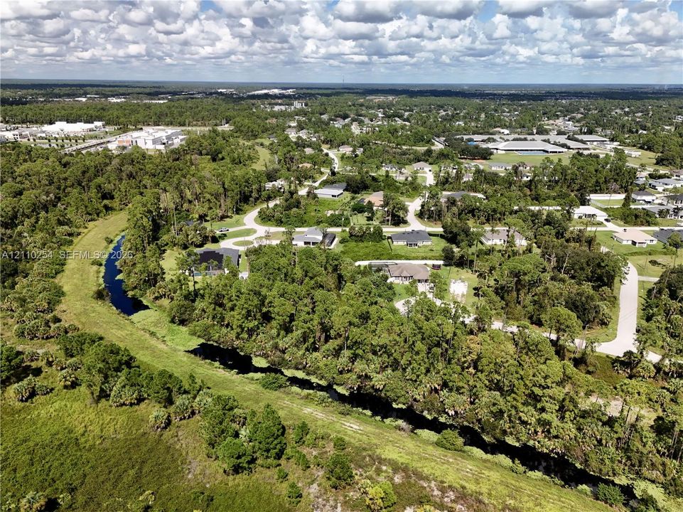 Aerial perspective featuring mature vegetation, established tree canopy, and an expansive natural waterway