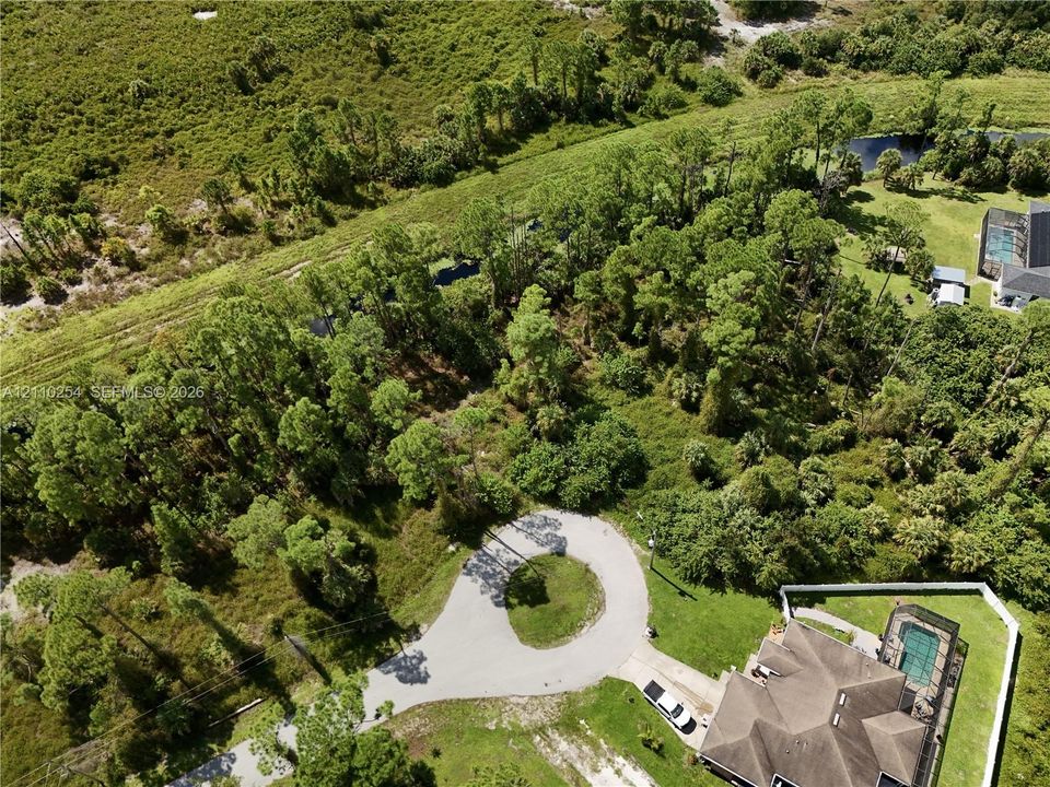 Aerial perspective of a cul-de-sac parcel featuring dense mature trees and native vegetation