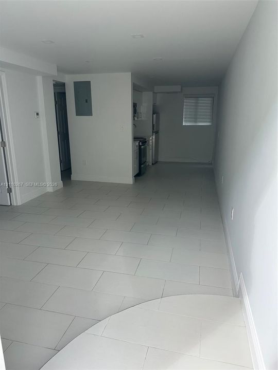 Open floor plan featuring large-format ceramic tile flooring, recessed ceiling lighting, and a neutral color palette