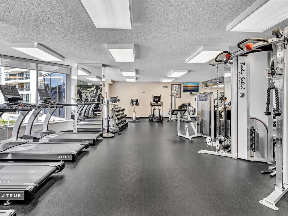 Fully Equipped Fitness Center Featuring a Reception Area, Spa, Extensive Exercise Equipment, and Dedicated Pilates Room