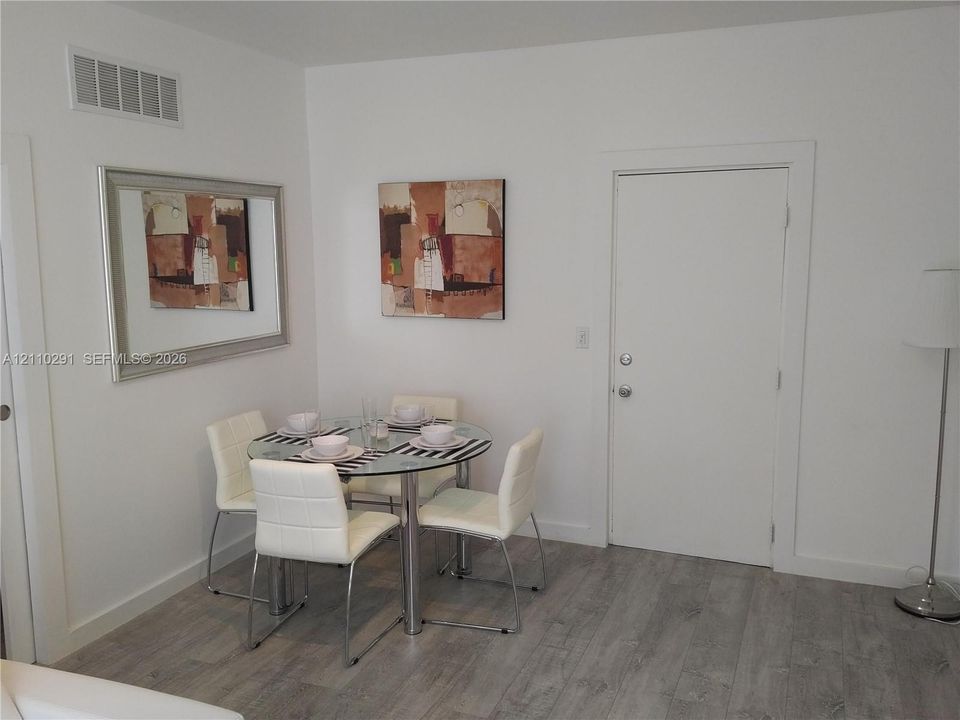 Wood-finish flooring paired with neutral wall tones and interior door with brushed nickel hardware