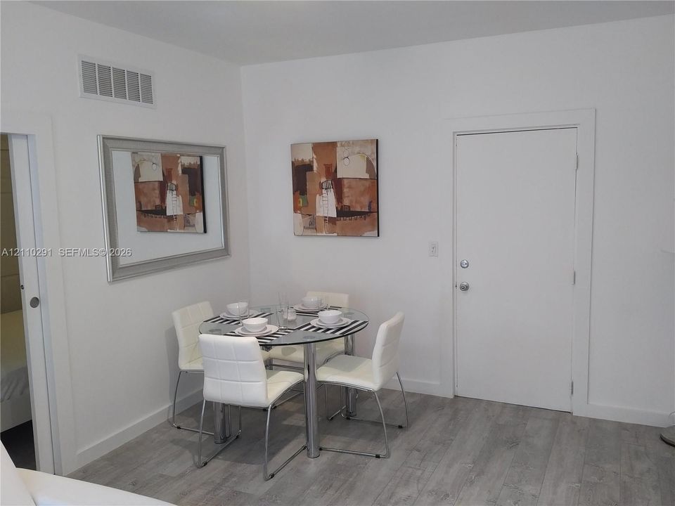 Neutral-toned wood-finish flooring and solid core white interior doors
