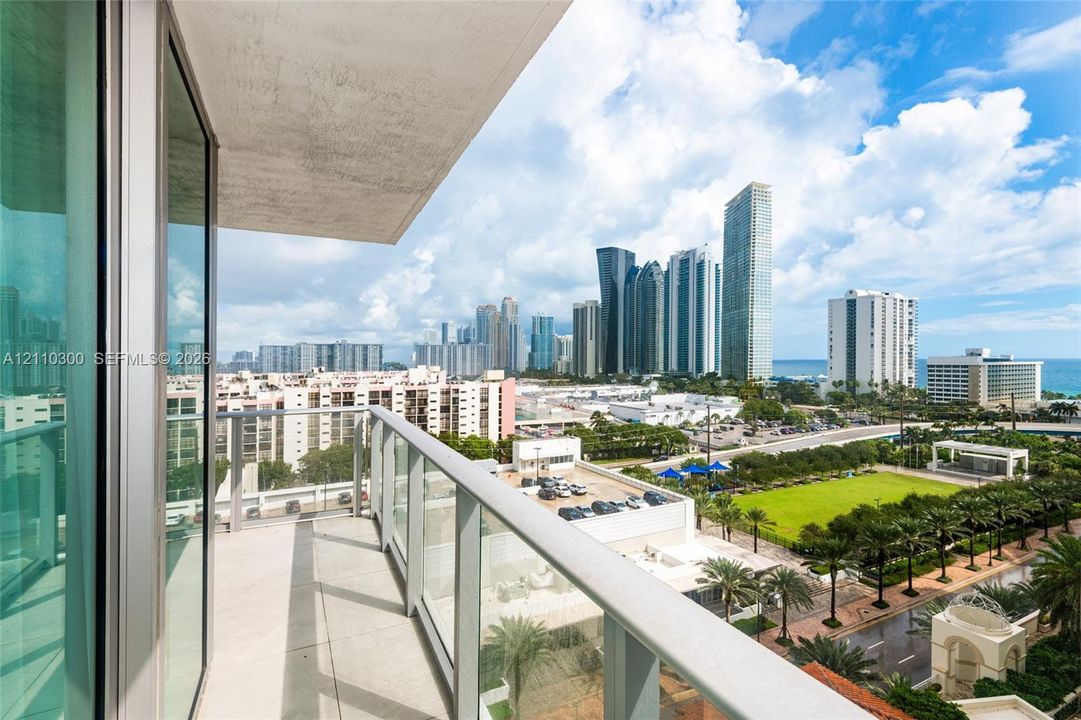 Private balcony featuring a glass panel railing and tile flooring. Ocean View