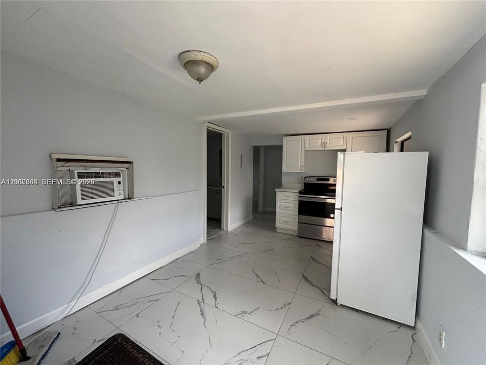 Large-format tile flooring, white cabinetry, and stainless-steel appliances