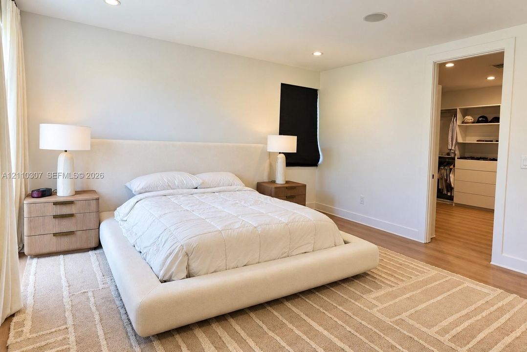 Bedroom featuring wood-finish flooring, recessed lighting, and a walk-in closet with built-in shelving