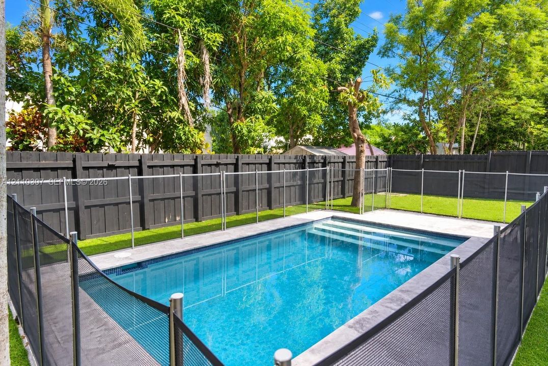 Private backyard featuring an in-ground swimming pool, concrete pool deck, and a perimeter wood-slat fence