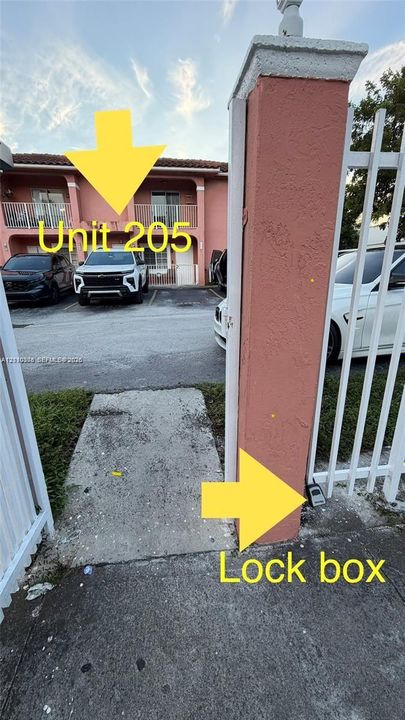 Two-story exterior featuring a balcony and a gated entrance with a masonry column