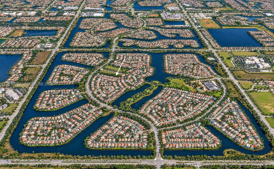 Aerial perspective of a planned community featuring winding residential streets and multiple surrounding waterways