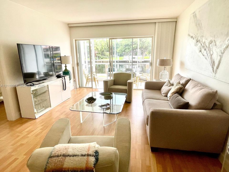 Living area featuring wood-finish flooring and expansive glass sliding doors