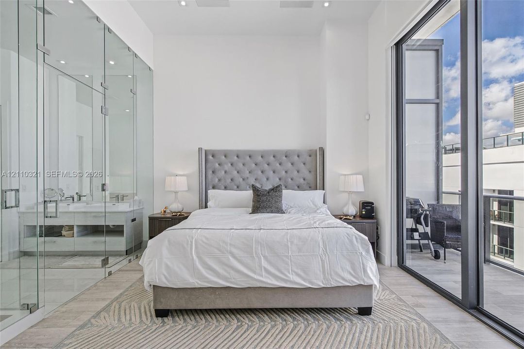 Floor-to-ceiling glass wall enclosure, full-height windows, neutral-toned flooring, and recessed ceiling lighting