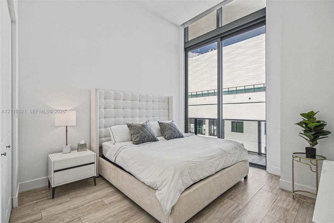 Floor-to-ceiling windows with integrated transom, wood-finish tile flooring, and neutral wall palette