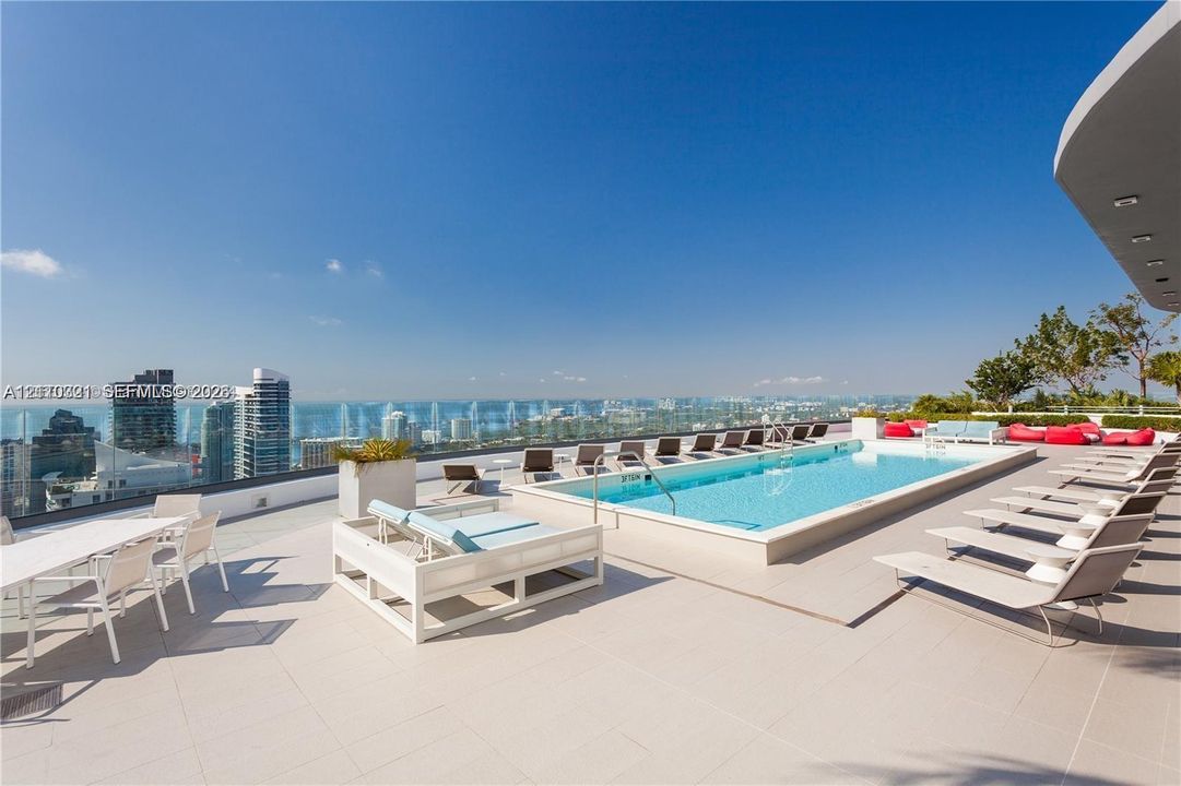 Rooftop terrace featuring an elevated swimming pool, large-format tile flooring, and a glass perimeter railing
