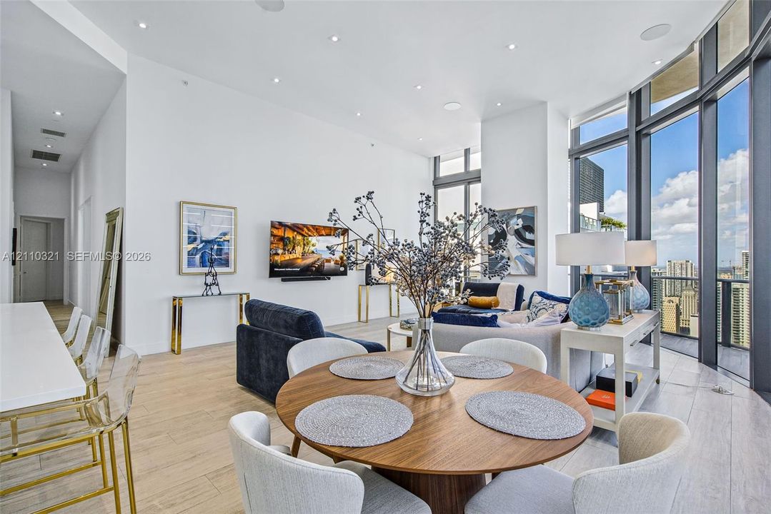 Expansive floor-to-ceiling windows, wood-finish tile flooring, recessed ceiling lighting, and soaring high ceilings