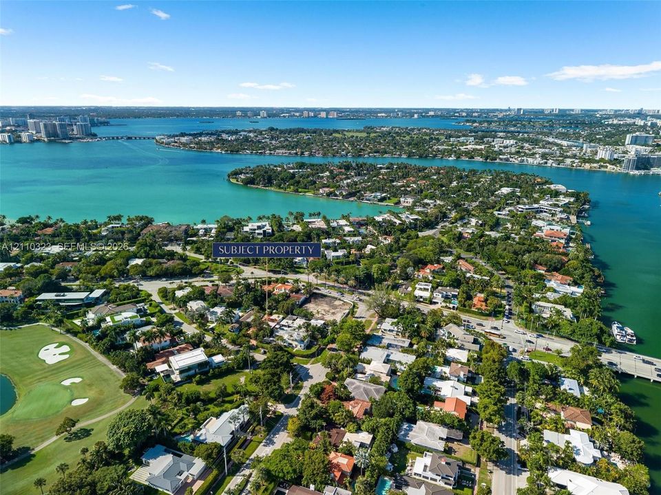 Aerial perspective of a coastal residential lot featuring mature perimeter vegetation and proximity to waterfront inlets