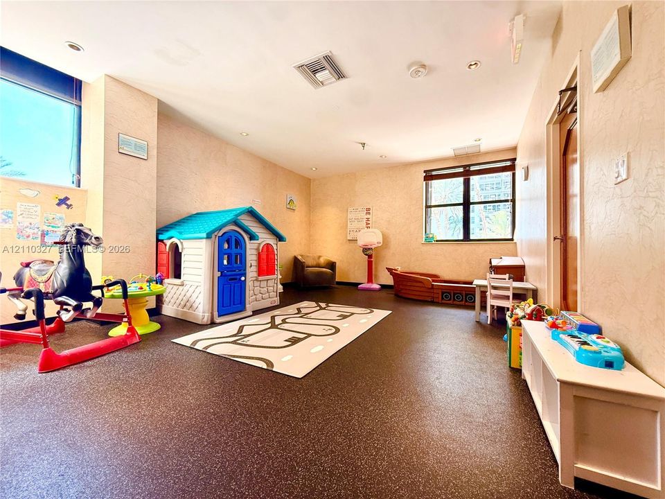 Open-concept room featuring high ceilings with recessed lighting, large windows, and durable flooring