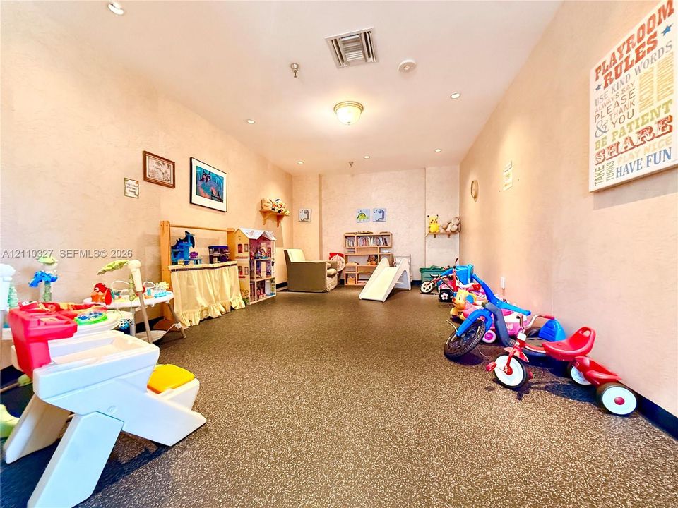 Flexible interior room featuring durable speckled flooring, recessed lighting, and wall-mounted shelving