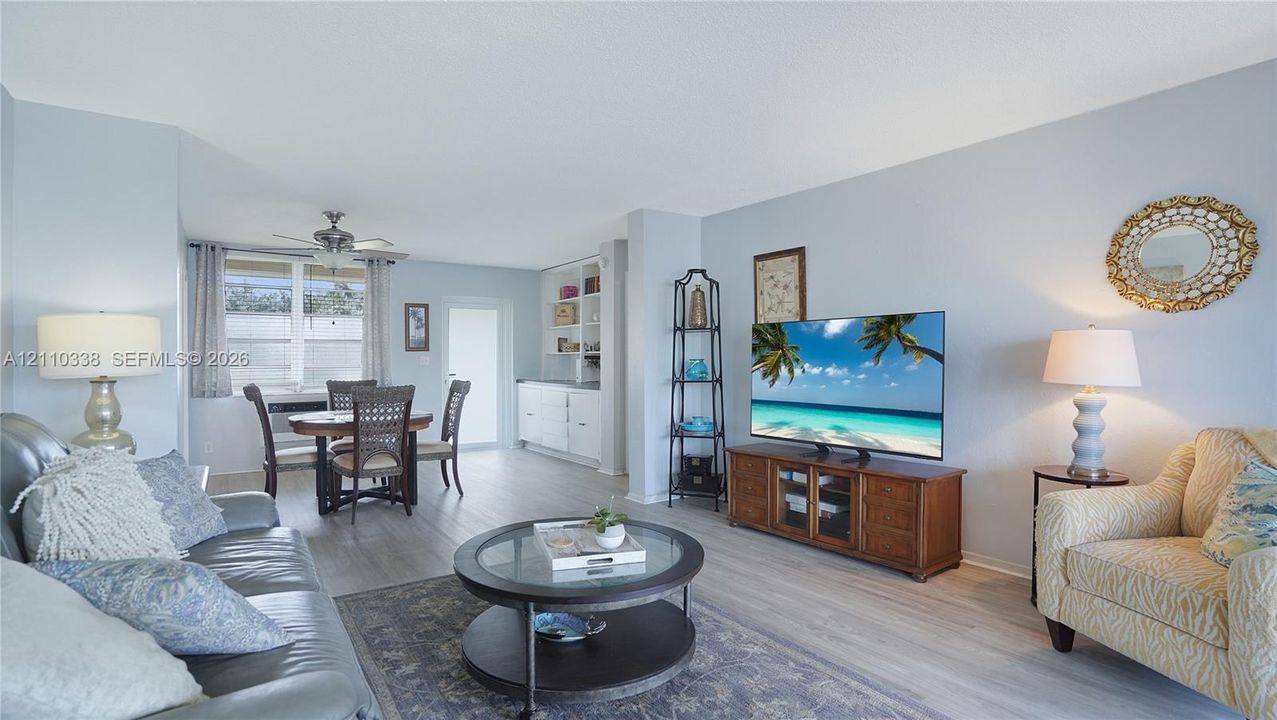 Living area featuring wood-finish flooring, recessed ceiling lighting, and built-in cabinetry