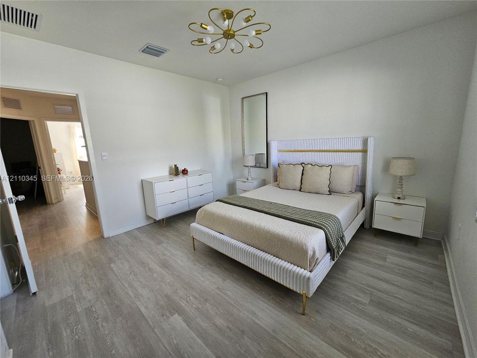 Interior space featuring wood-finish flooring, a multi-arm brass-tone chandelier, and a neutral color palette