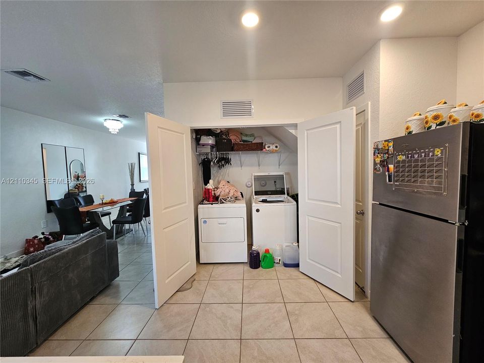 Laundry closet with built-in shelving, tile flooring, and recessed ceiling lighting