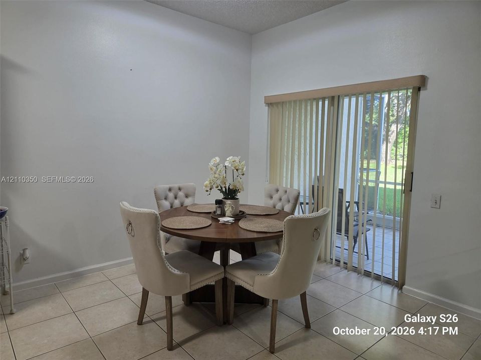 Neutral-toned ceramic tile flooring and sliding glass doors featuring vertical blinds