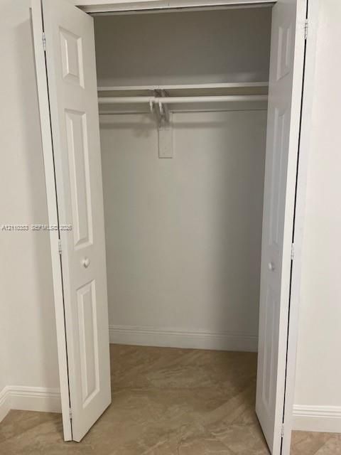 Reach-in closet featuring white six-panel bifold doors, an integrated upper shelf, and a horizontal hanging rod