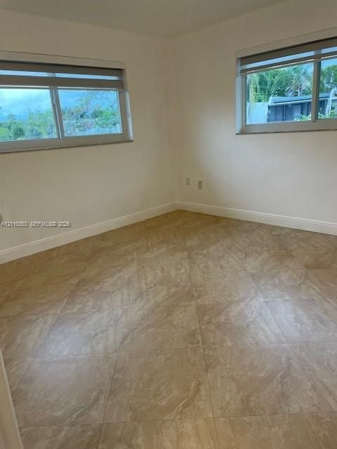 Neutral-toned tiled flooring, dual sliding-frame windows, and high-contrast window treatments