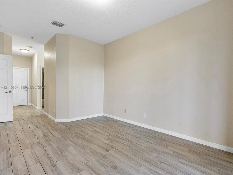Neutral wall palette with wood-finish tile flooring and interior panel doors