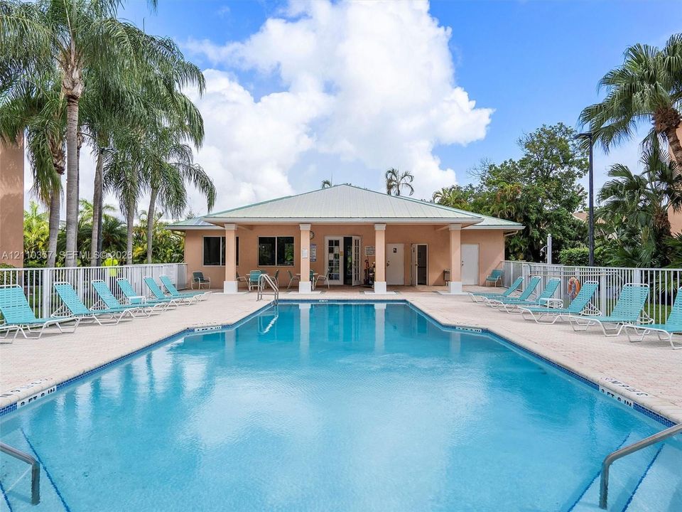 Swimming pool with tile edging, concrete pool deck, covered pavilion, and perimeter fencing