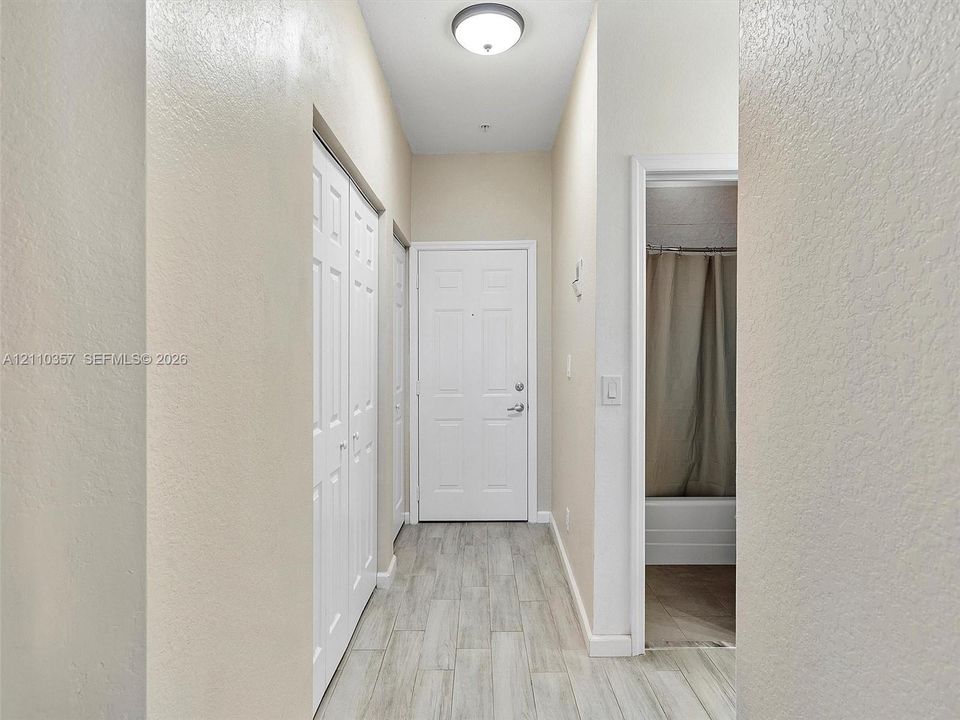 Entryway featuring wood-finish tile flooring, recessed ceiling lighting, and multi-panel interior doors